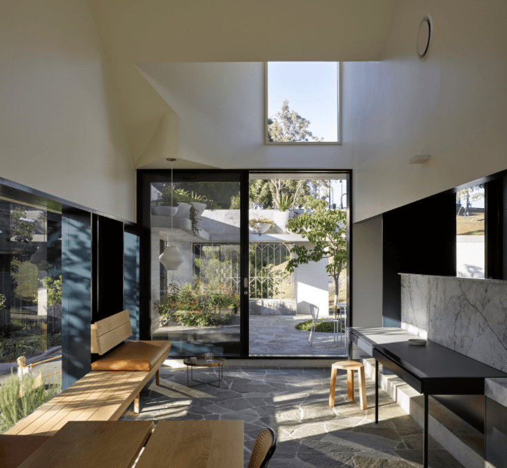 A living room with a large window and a desk