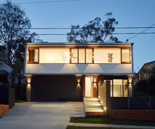 A house with a lot of windows is lit up at night