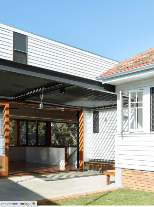 A white house with a red roof and a covered porch