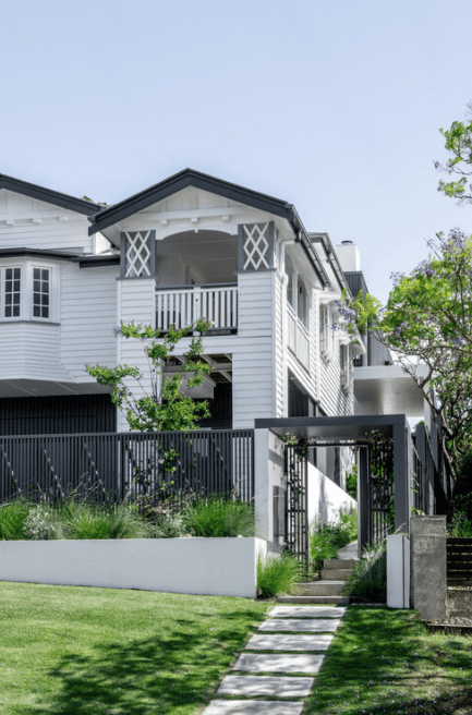 A large white house with a lush green lawn in front of it.