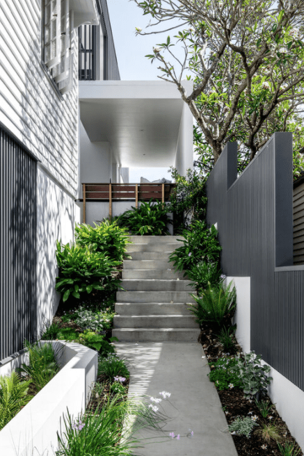 A walkway leading up to a house with stairs and plants.