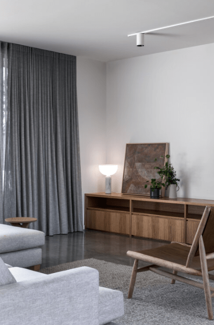 A living room with a couch , chair , and curtains.