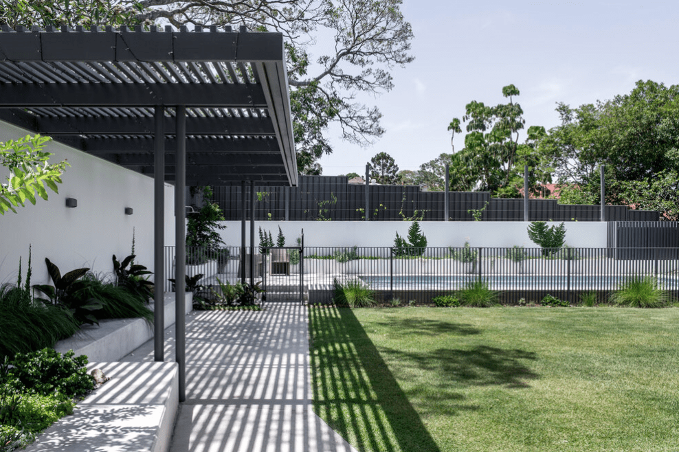 There is a pergola in the backyard of a house.