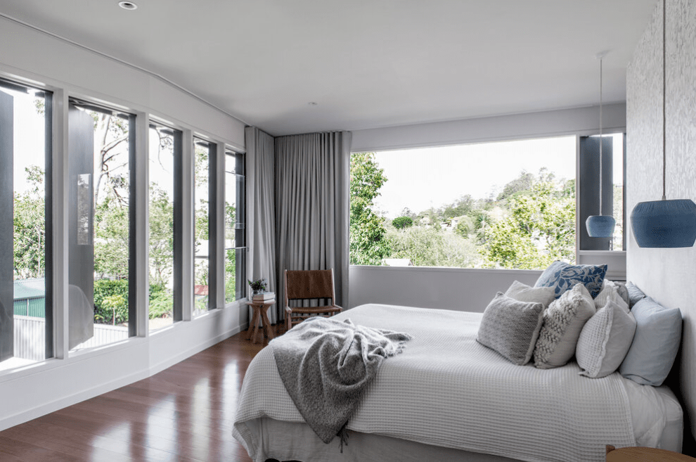 A bedroom with a large bed and lots of windows.