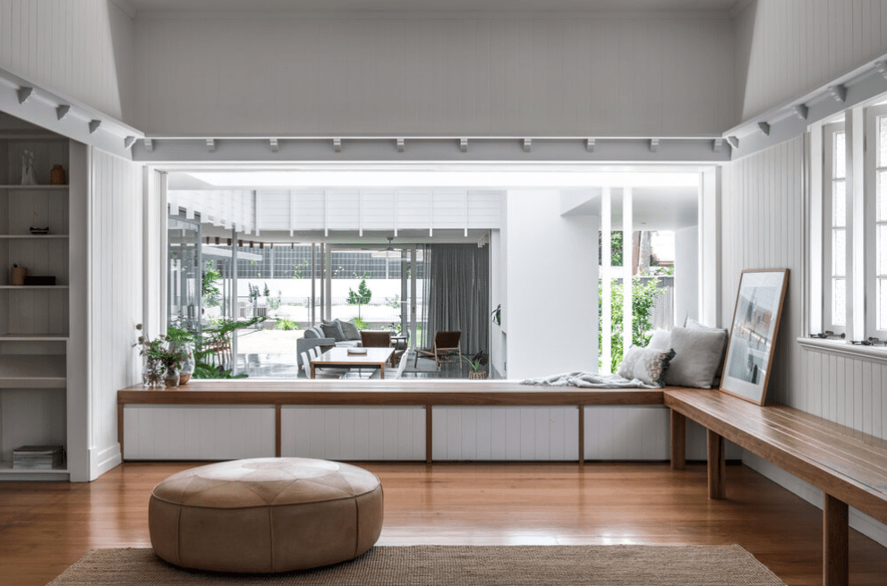 A living room with a large window and a bench.