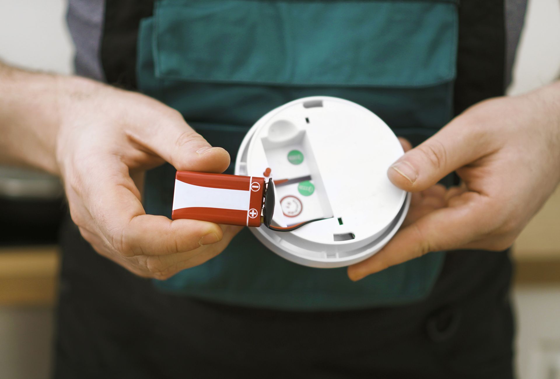 Man checking battery in smoke detector