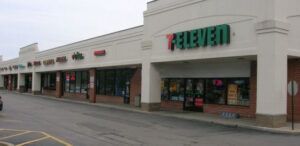 A 7 eleven store is located in a shopping center.