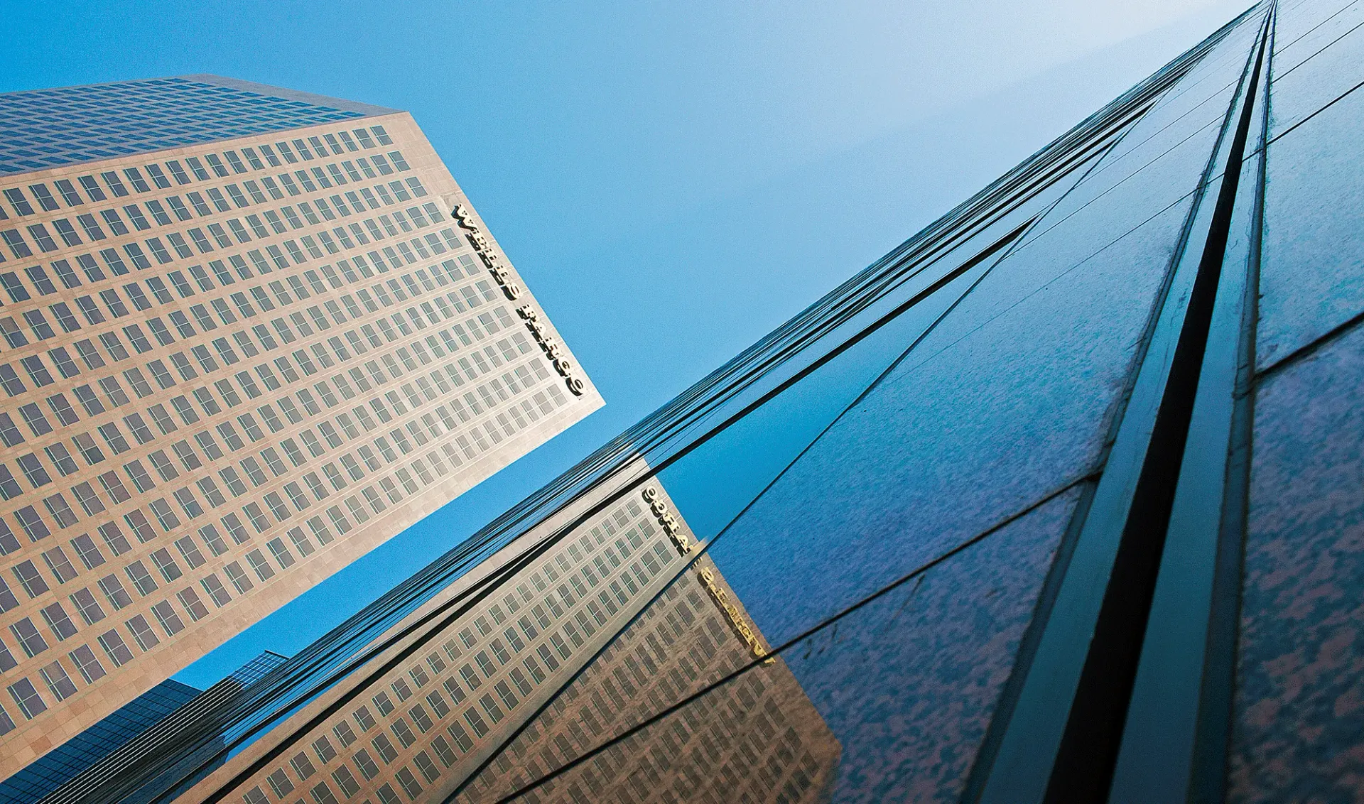 a bridge is reflected in the glass of a building