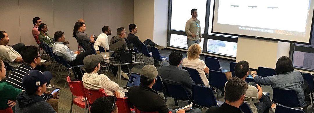 a group of people are sitting in a room watching a presentation .