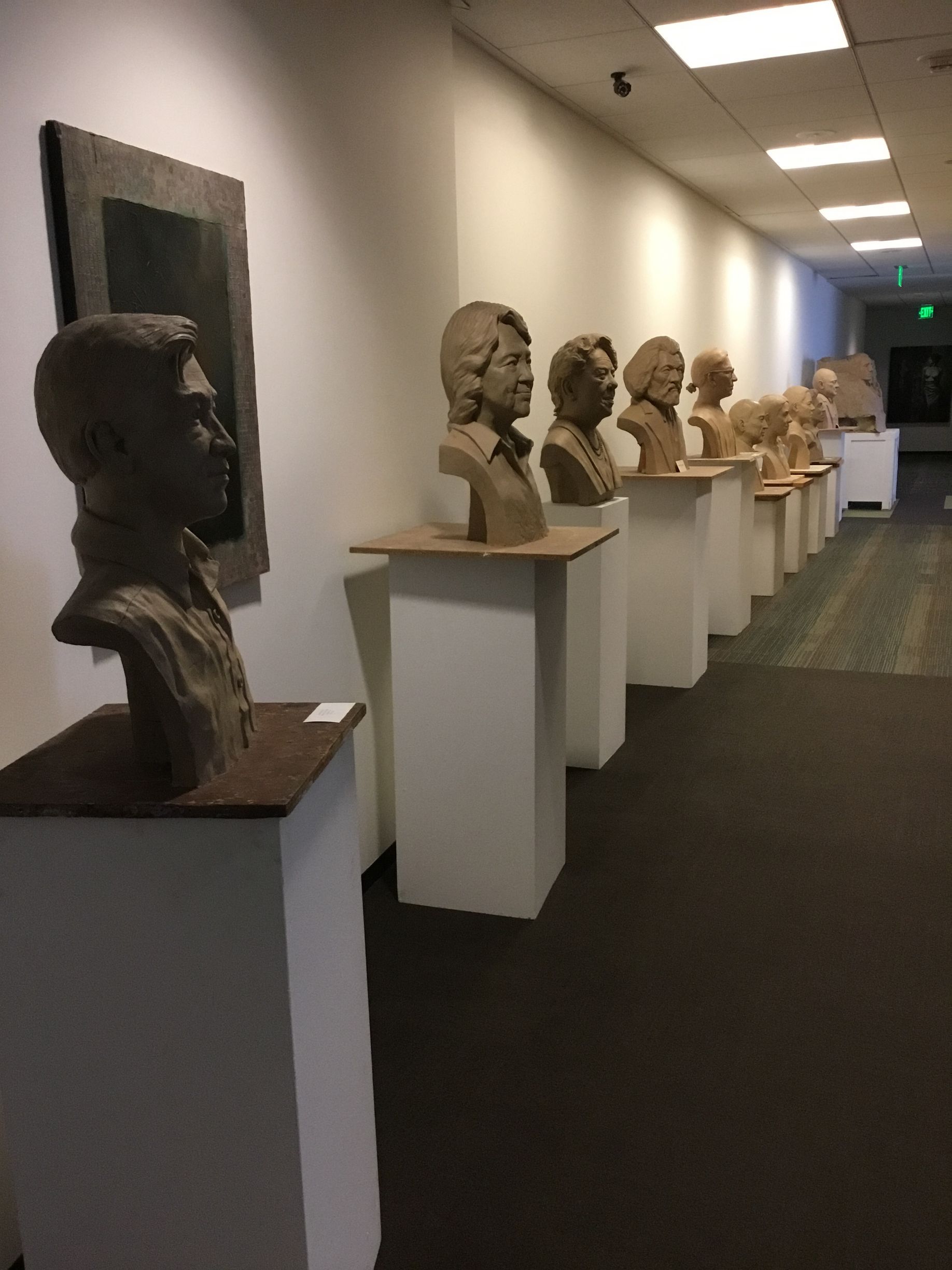 a hallway with a row of busts on display
