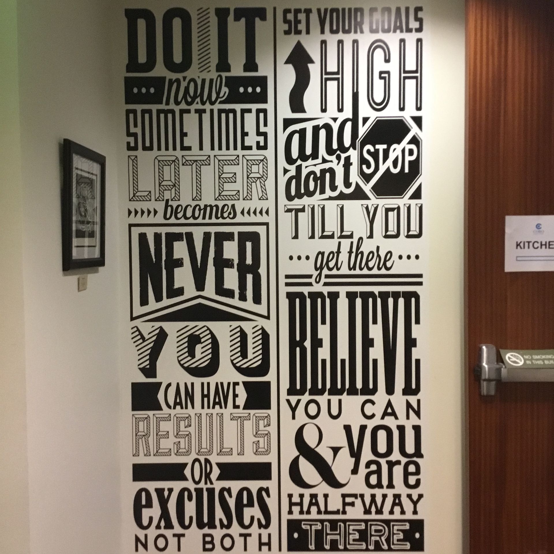 a sign on a wall that says do it now sometimes later don t stop till you get there never you believe