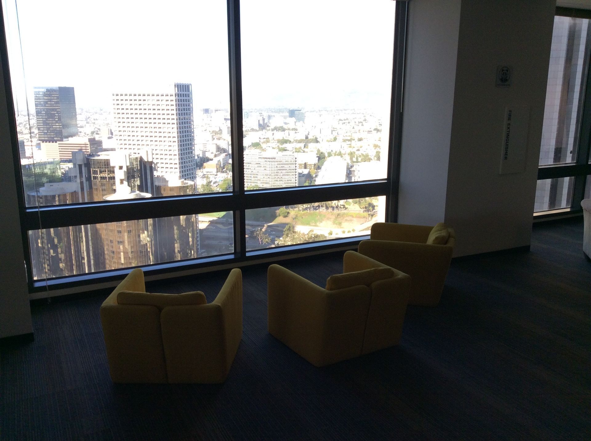 two chairs are sitting in front of a window with a view of a city .