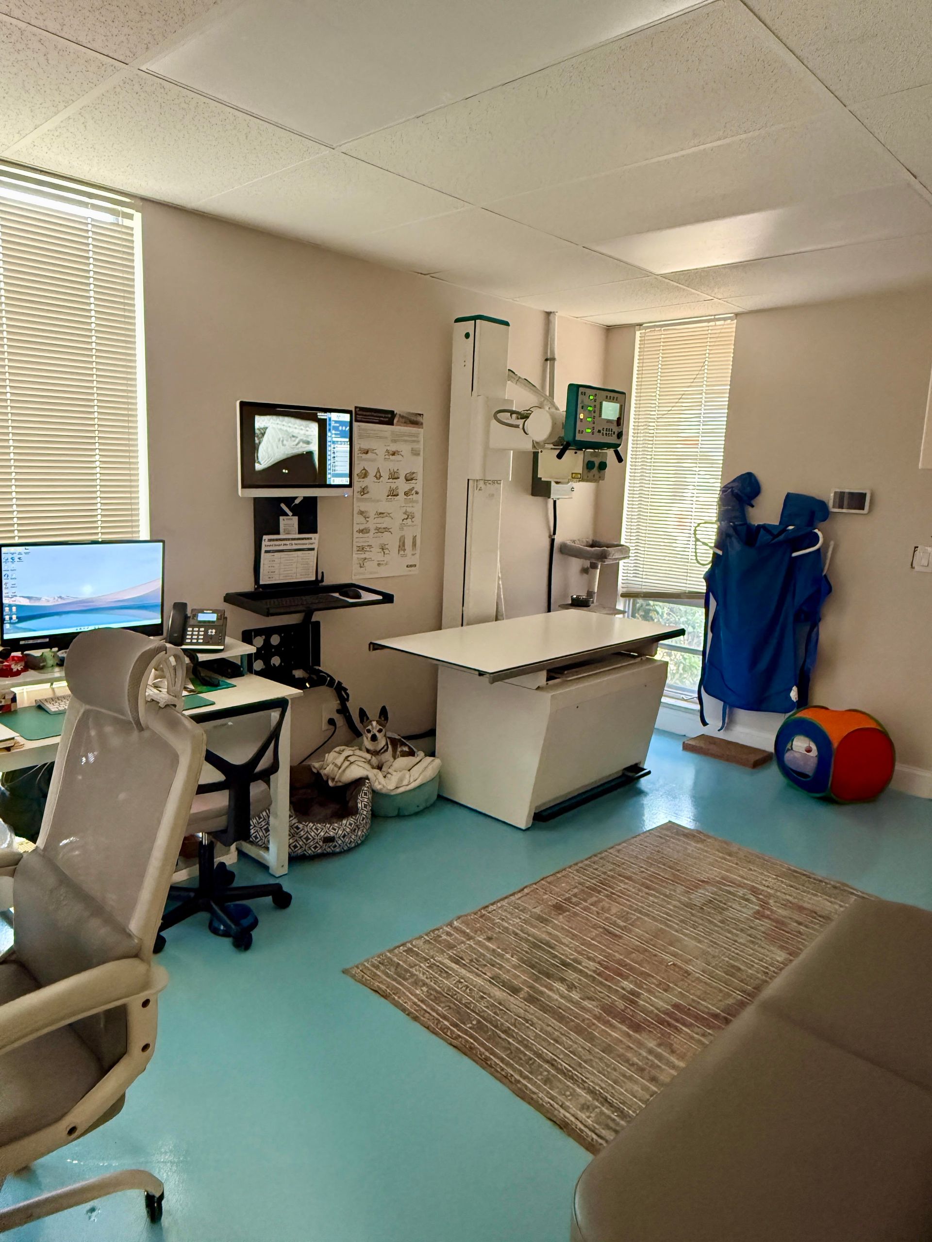 An x-ray machine is sitting on a table next to a computer monitor