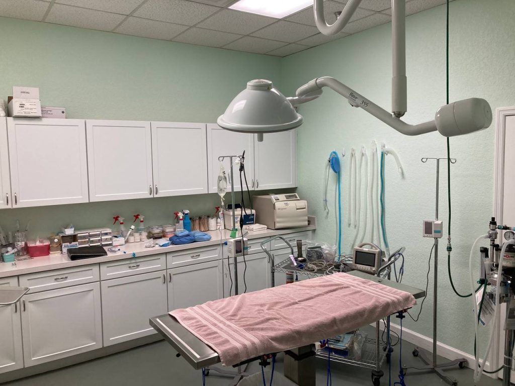 An empty operating room with a pink towel on the bed.