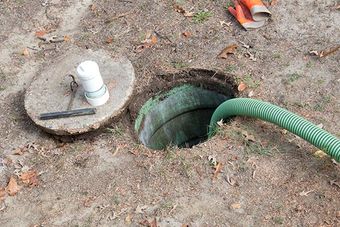 opening of grease trap with hose inside