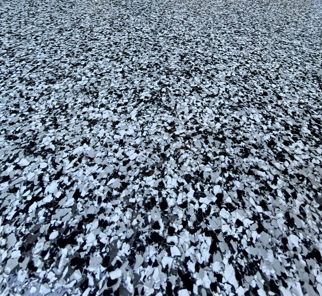 Close-up of a speckled floor with black, white, and gray flakes.