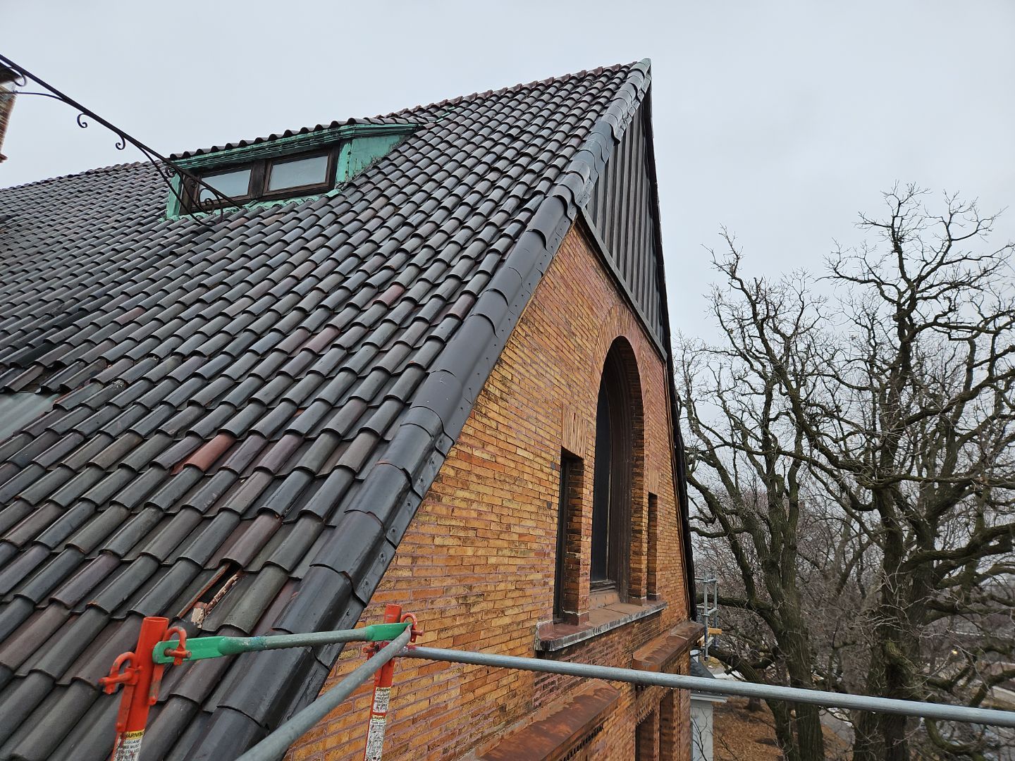 a brick building with a tiled roof and a window on the side .