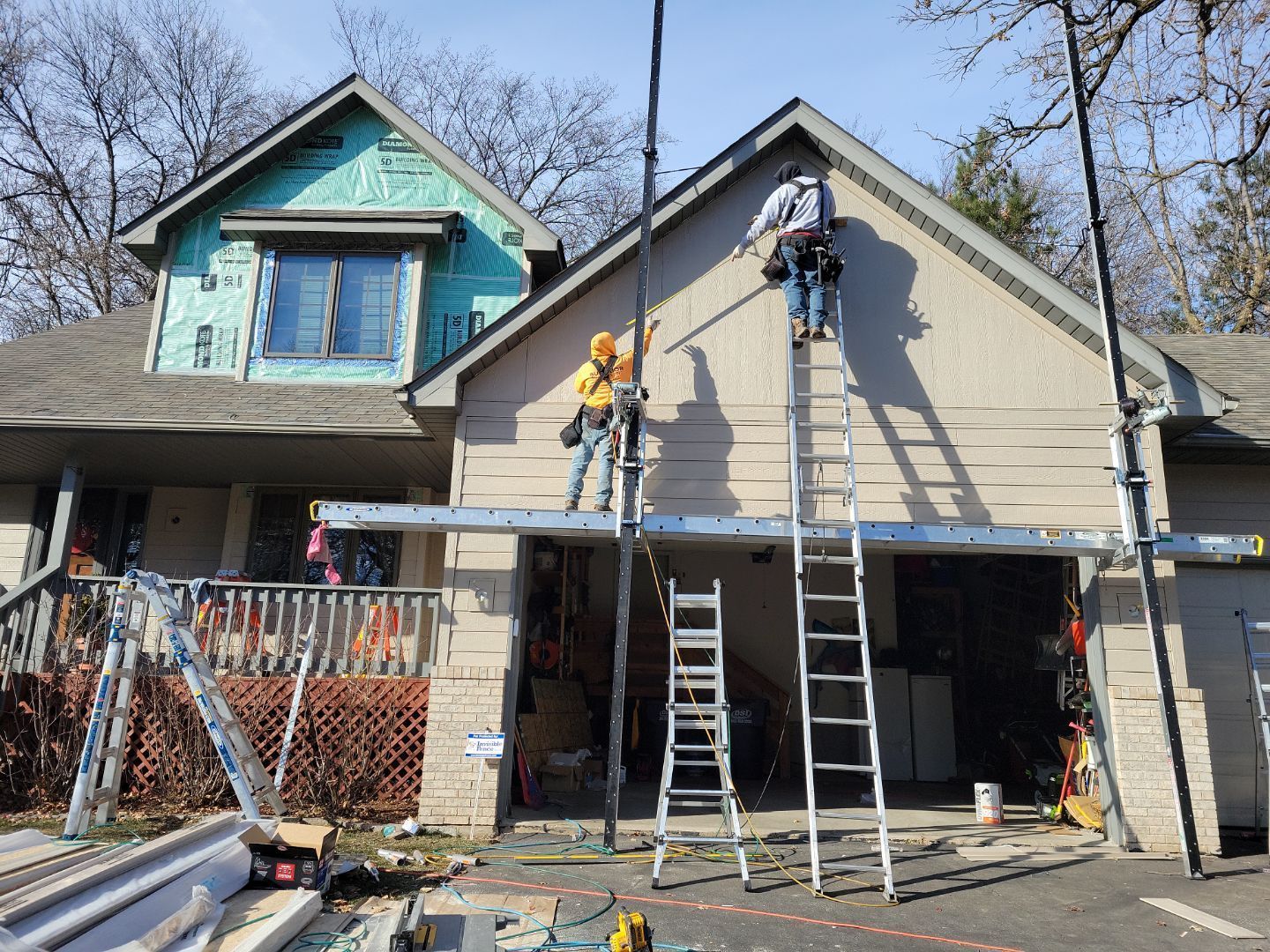 a group of men are working on the side of a house .