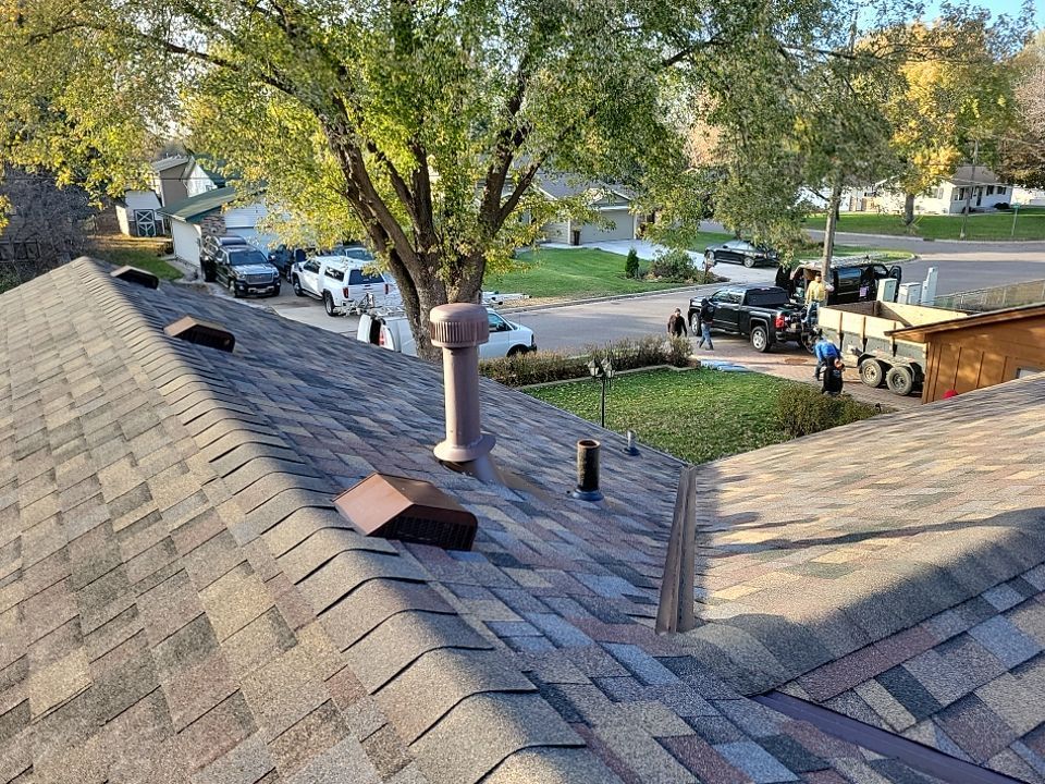 a red roof with a black truck parked on the side of the road .