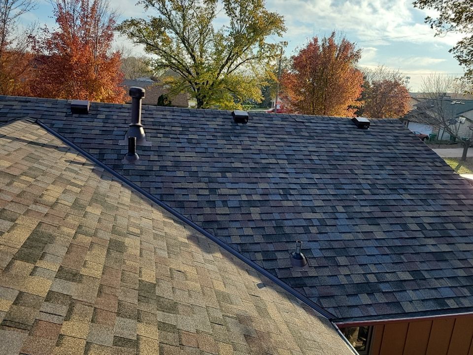 a roof with a chimney on it and trees in the background .