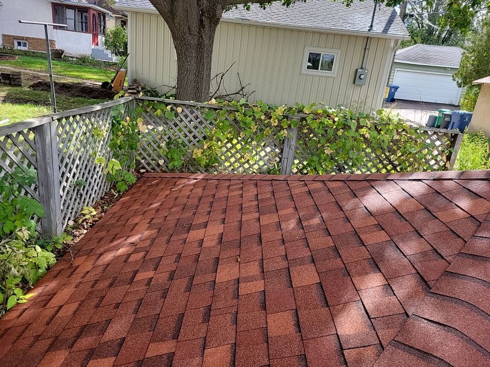 a brick deck with a fence and a tree in the background .