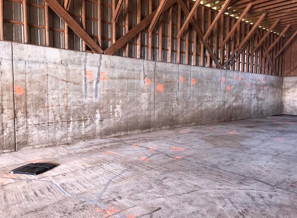 Un grand mur de béton dans un bâtiment avec des poutres en bois.