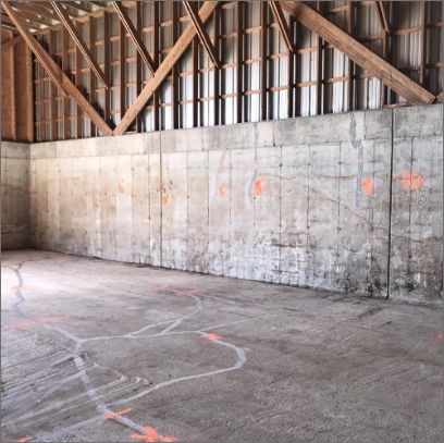 Une pièce vide avec un mur en béton et un plafond en bois