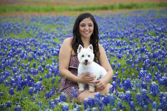 Lifestyle image of cute young woman holding dog and smiling - Bastrop, TX - K9 Mastery