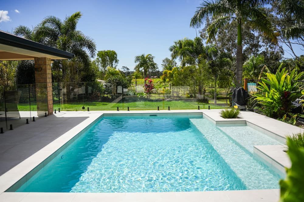 Rectangular Pool With Turquoise Water Surrounded by a White Patio — Concrete Pool Projects in Gladstone Central, QLD