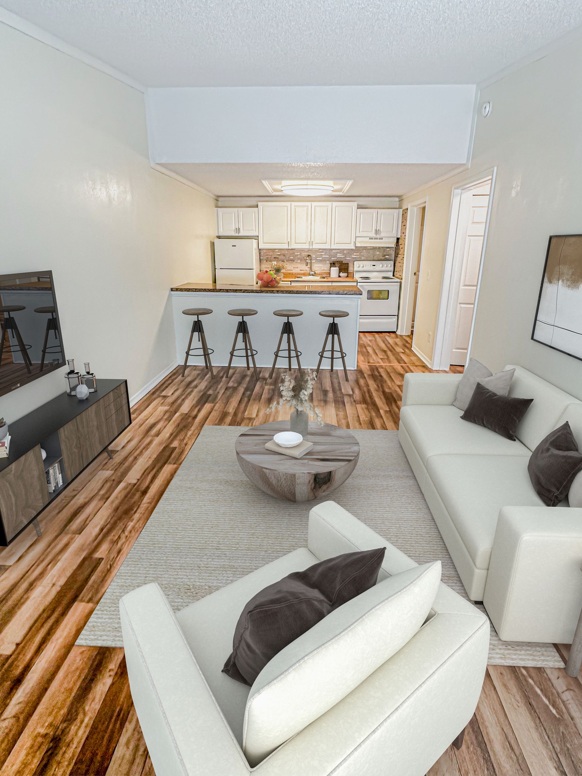 Photo of a living room with a barstool area and a kitchen in the background