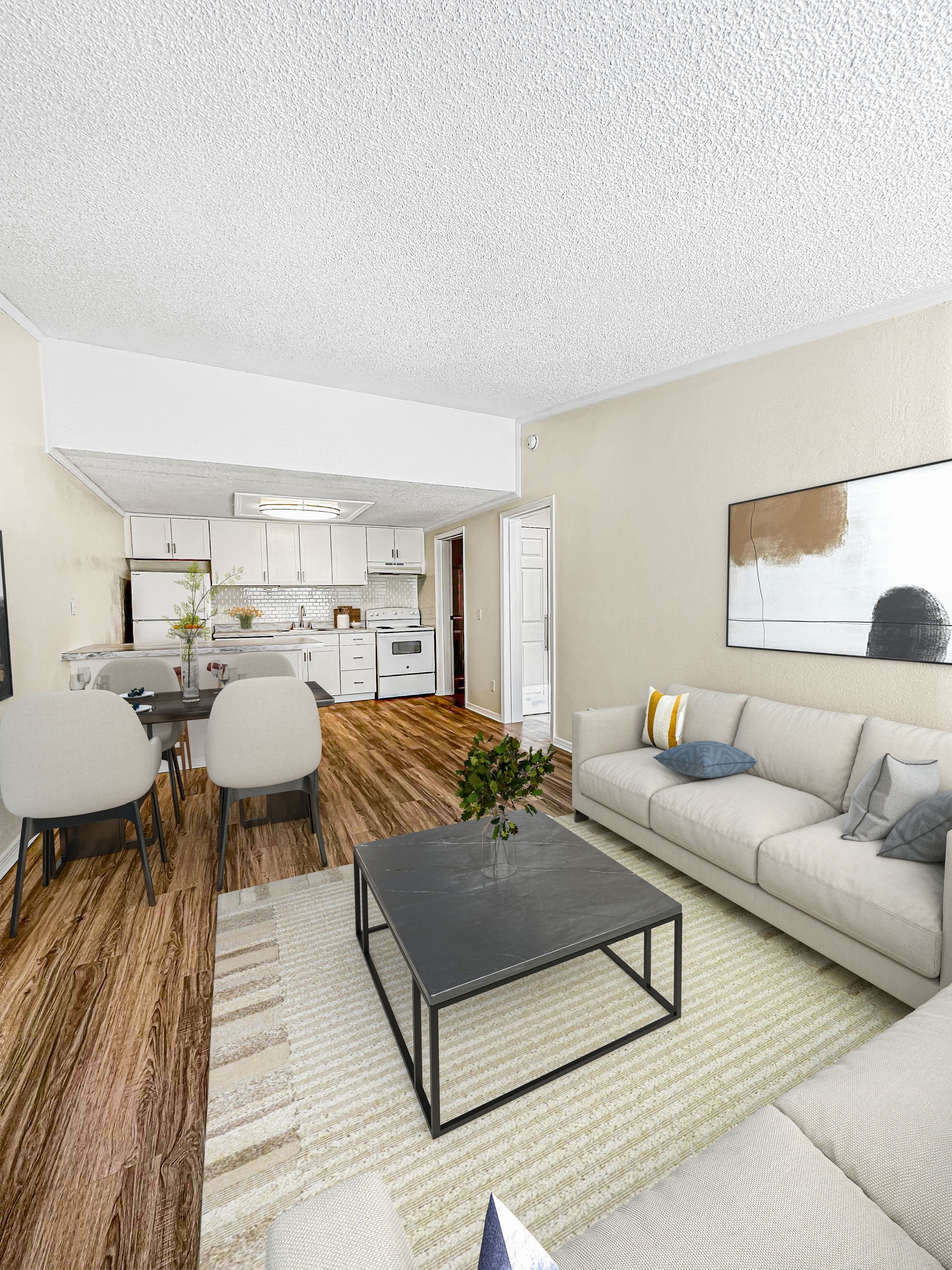 Photo of a living room that leads to a kitchen in the background