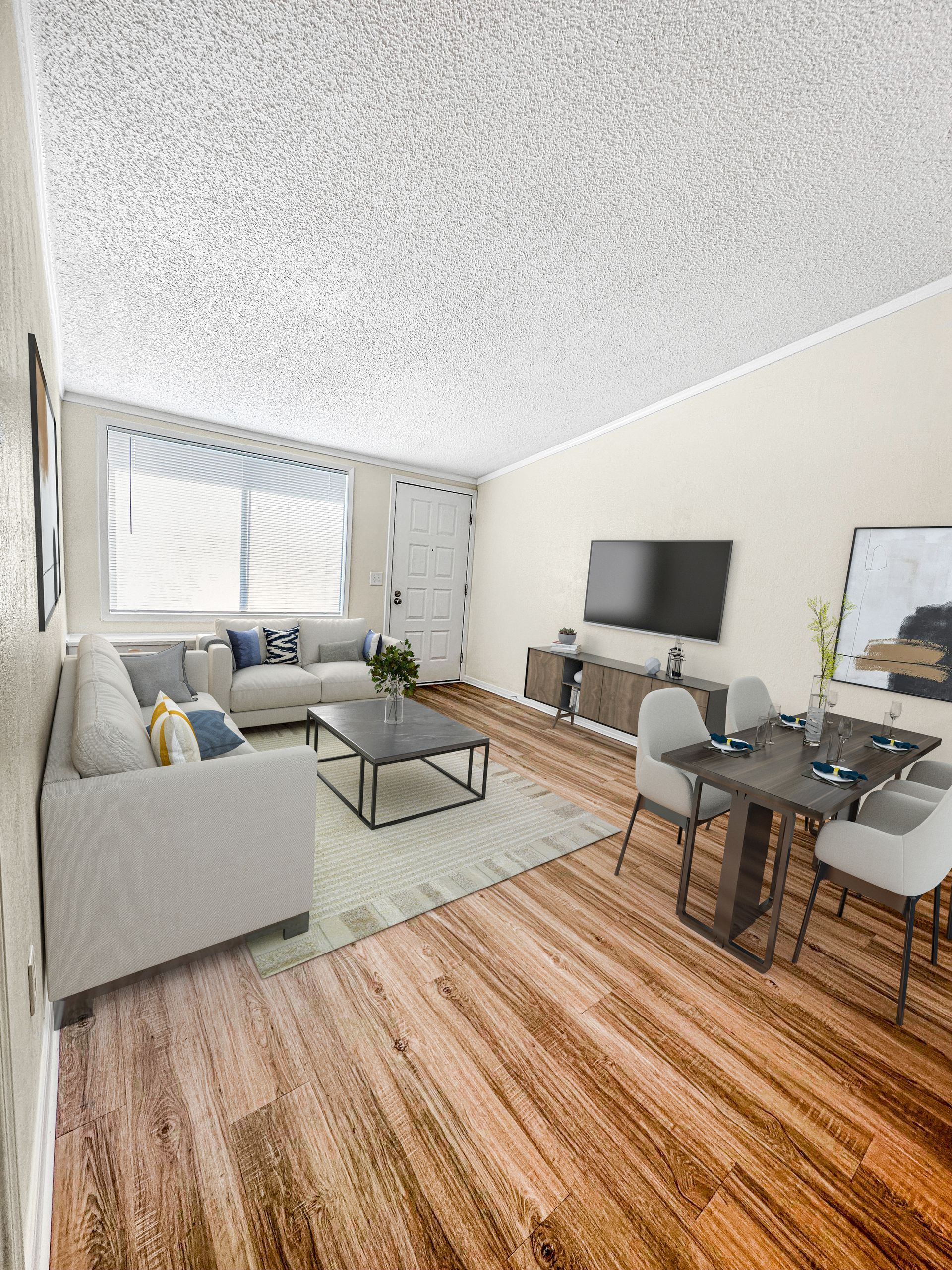 Photo of a living room, showing a couch, furniture and a mounted television