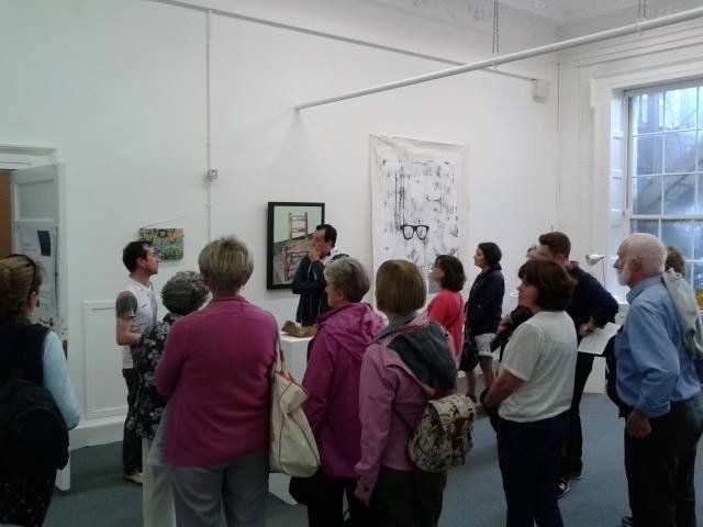Photo showing gallerist / curator Olivier Cornet with a group of visitors on a private tour of his Dublin art gallery