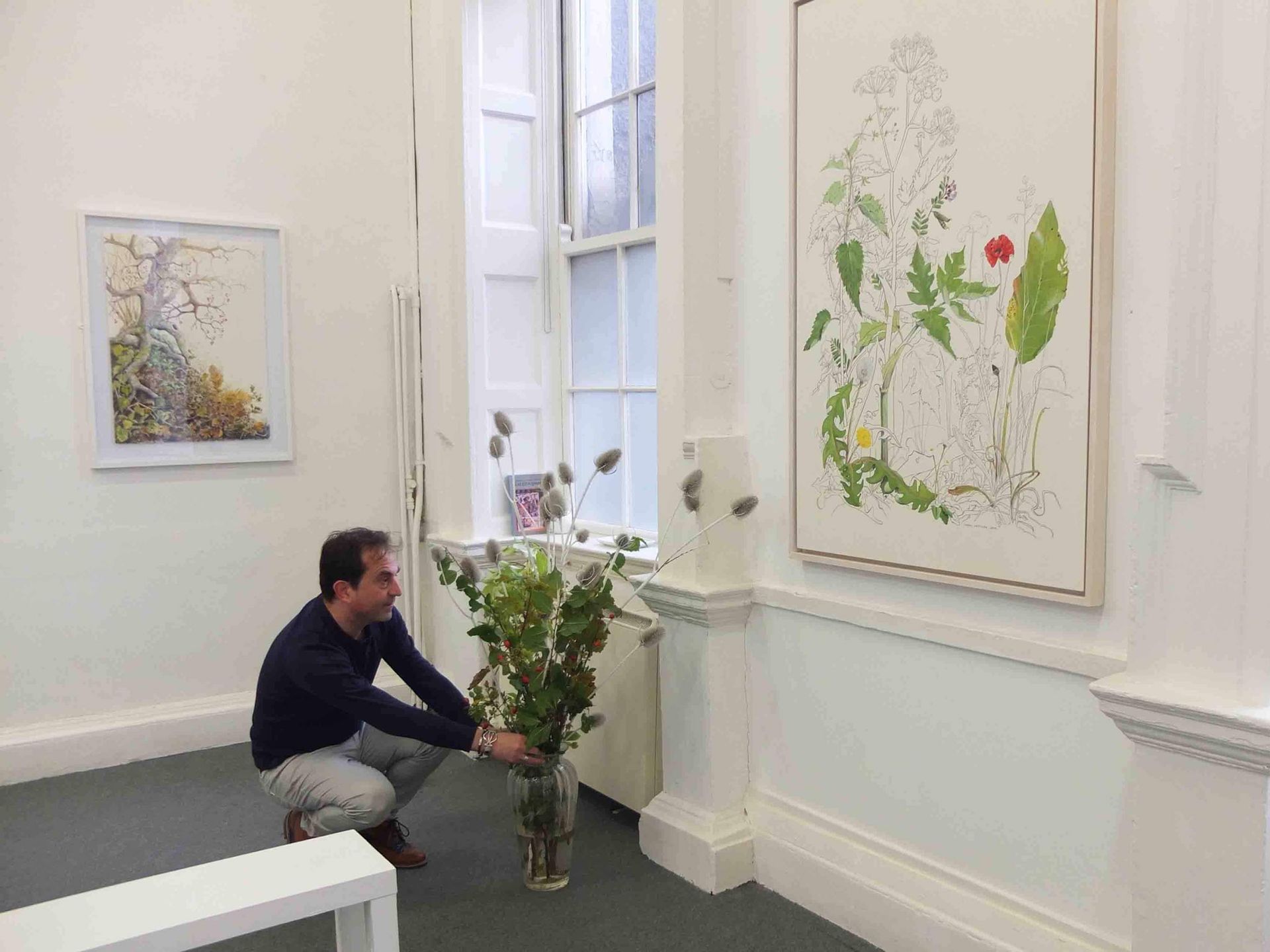 Gallerist Olivier Cornet putting the finishing touches to Yanny Petters’s show ‘HEDGEROW, Stories from a linear world’ before the arrival of the crowd on opening day Sunday 13 October 2019. The painting on the wall (right, between the two windows) is titled 'The Plants we played with, now part of the collection of the National Gallery of Ireland, Dublin
