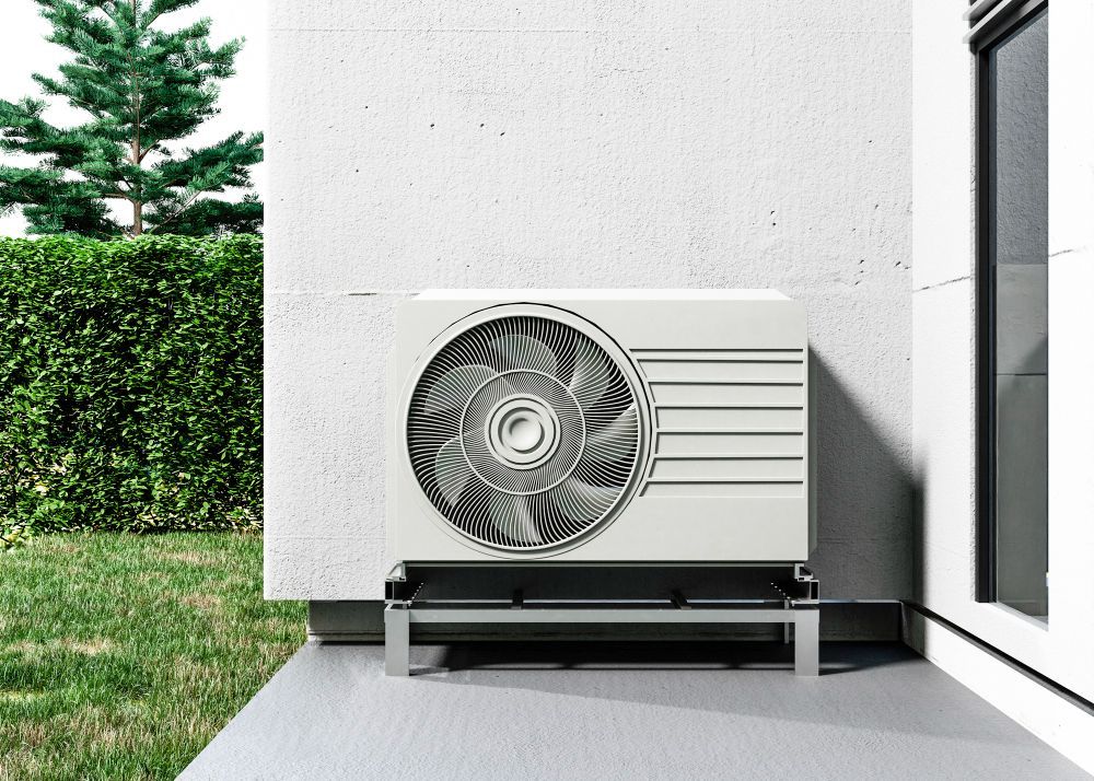 a white air conditioner is sitting on the side of a building