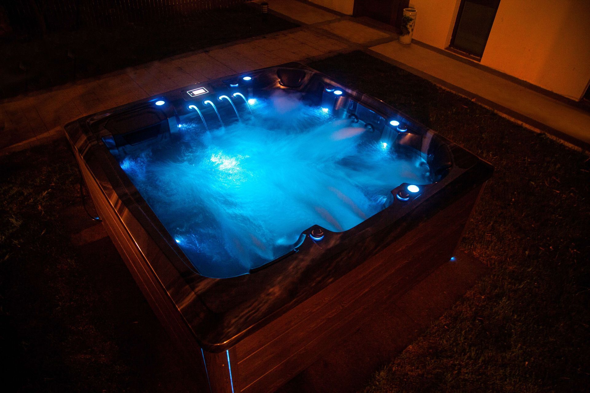 Pacific Spa hot tub with its lights on at night
