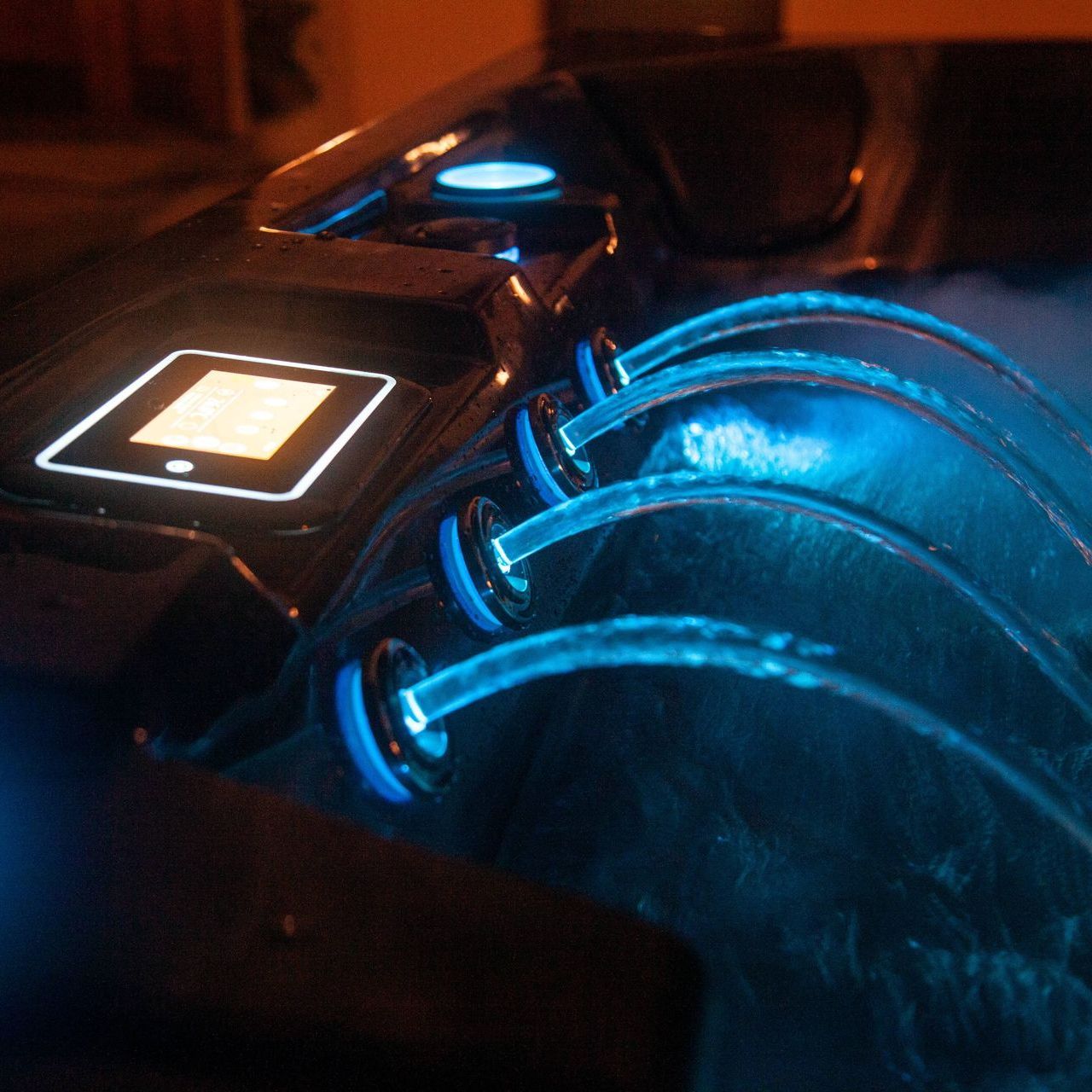 Hot Tub jets at night with blue light View of a hot tubs jet waterfall at night with blue glowing light.