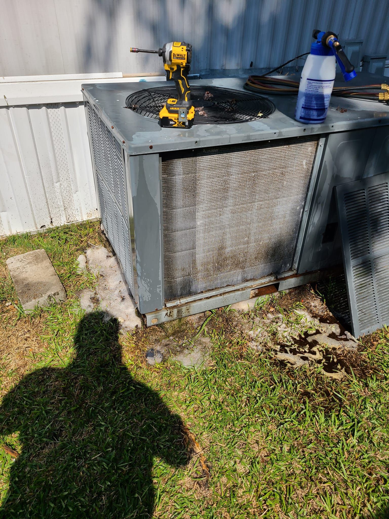 Woman in straw hat smiles, holding wine glass near a lake.