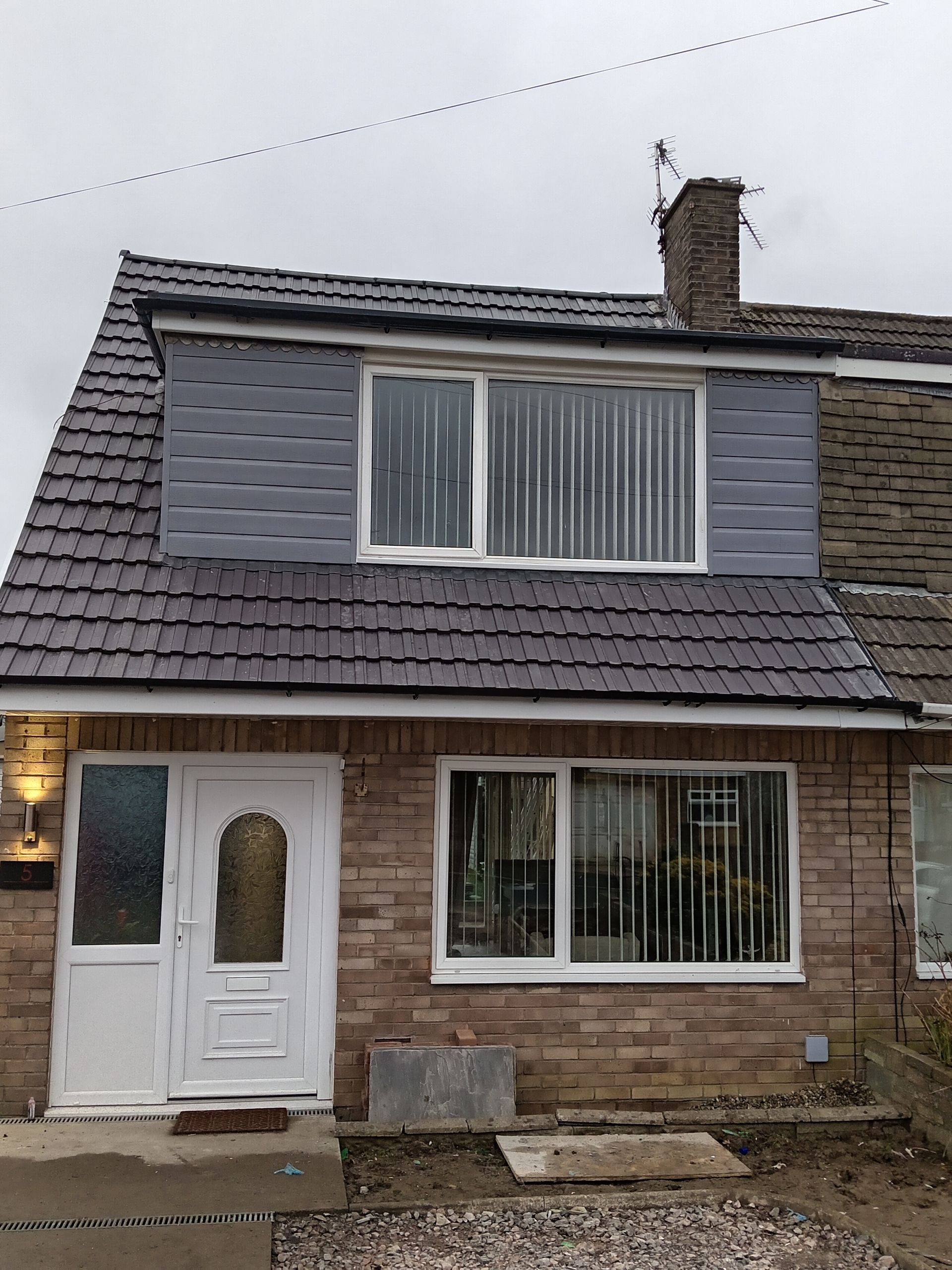 An aerial view of a tiled roof with houses in the background