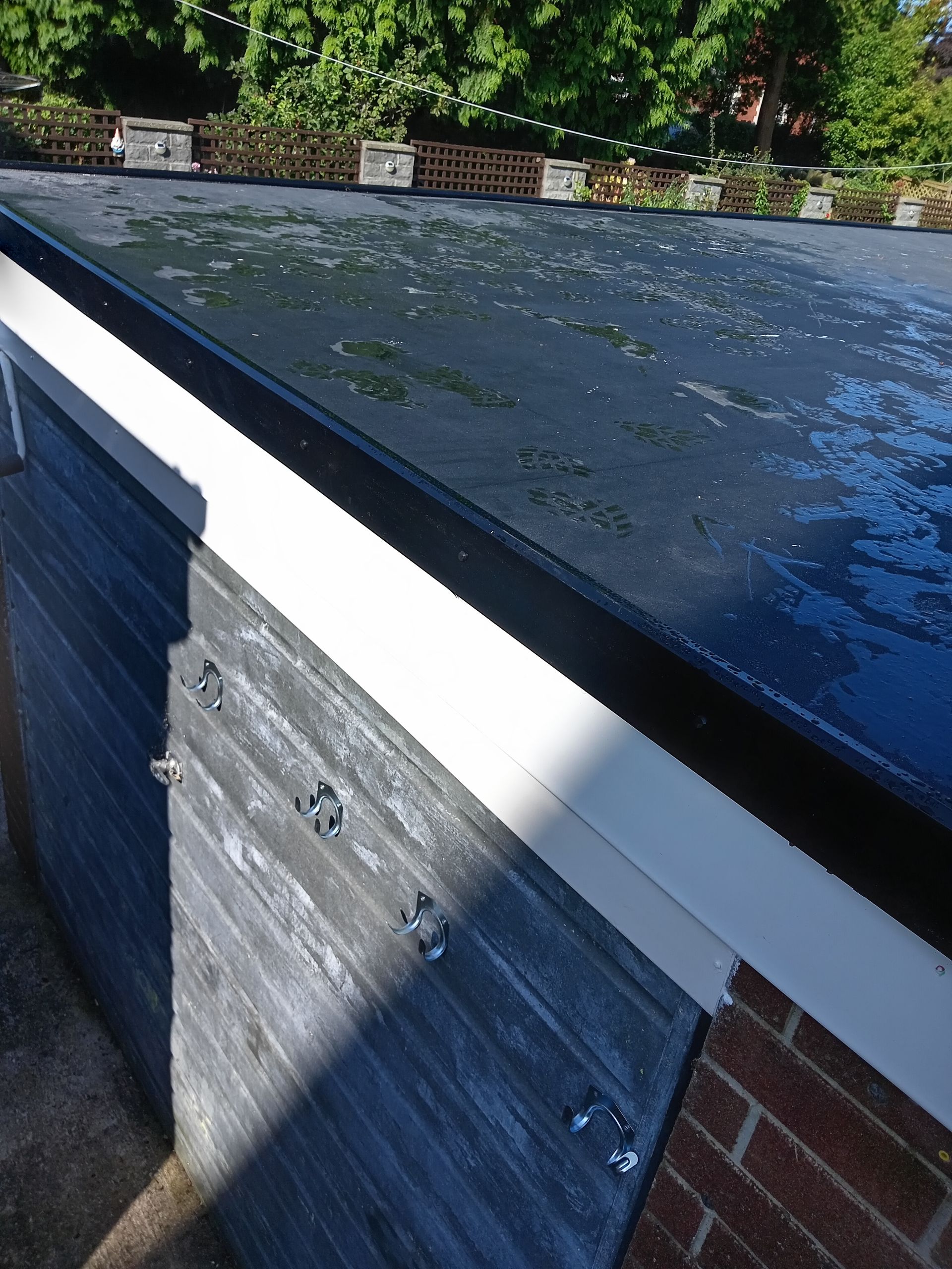 A black roof is sitting on top of a brick building.