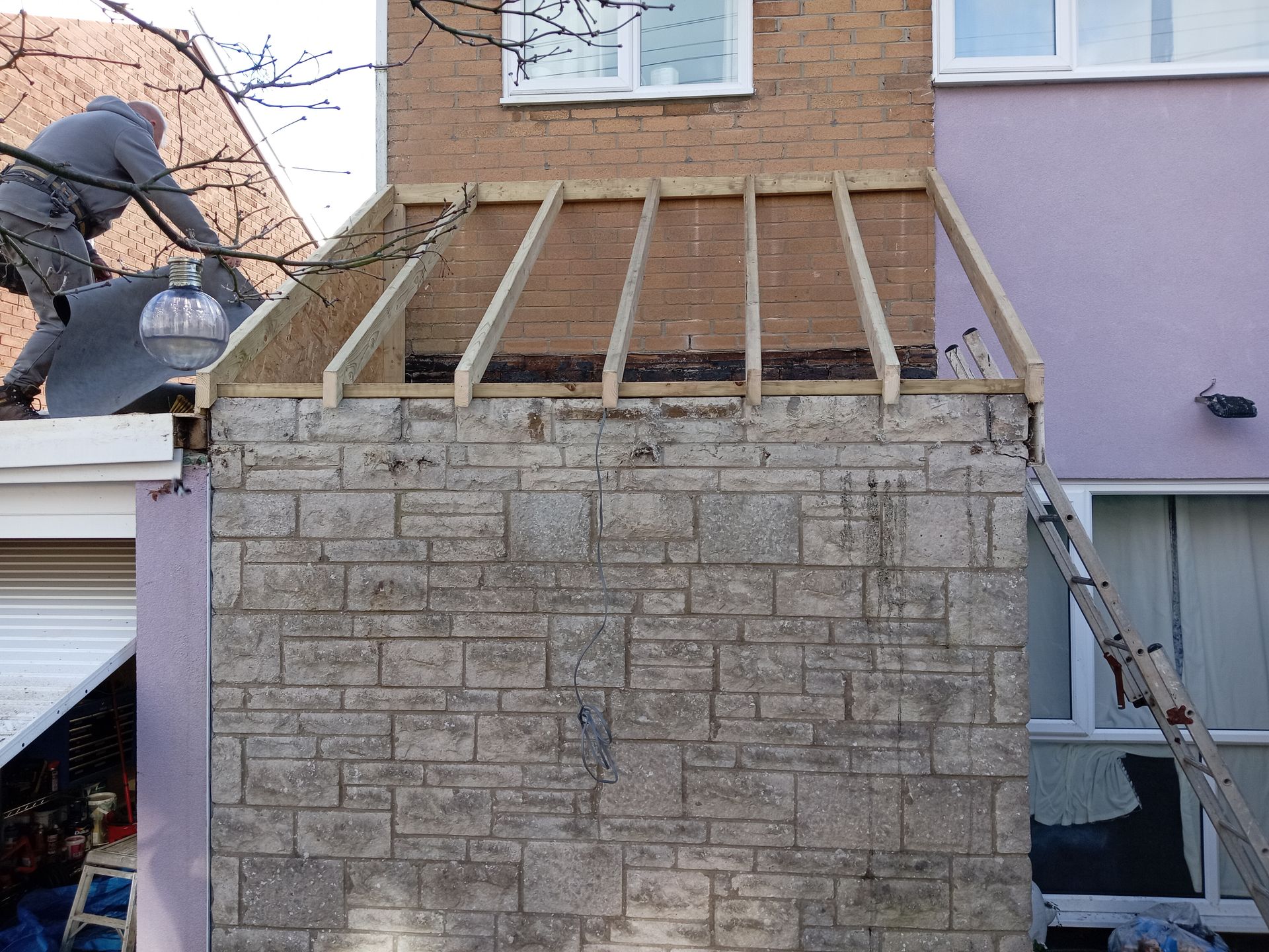 A wooden structure is being built on top of a brick building