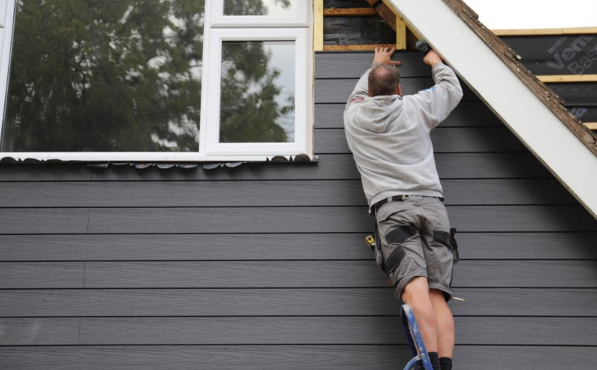 A man is standing on a ladder on the side of a building.