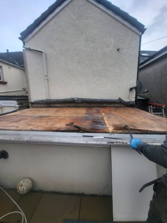 A man is working on the roof of a house.