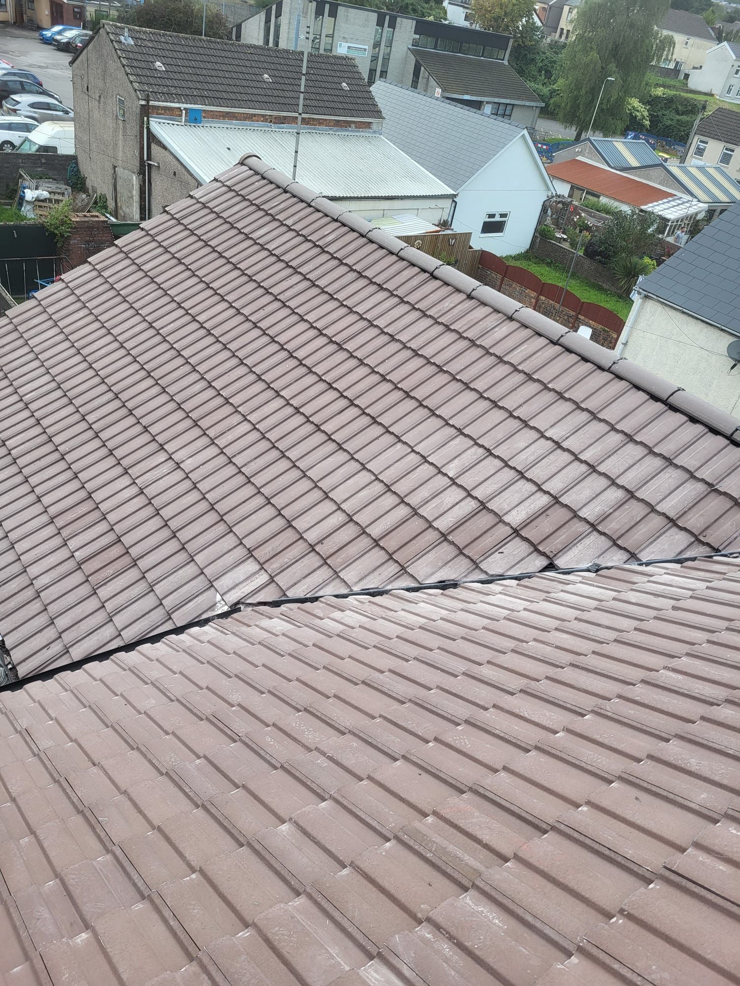 An aerial view of a tiled roof with houses in the background