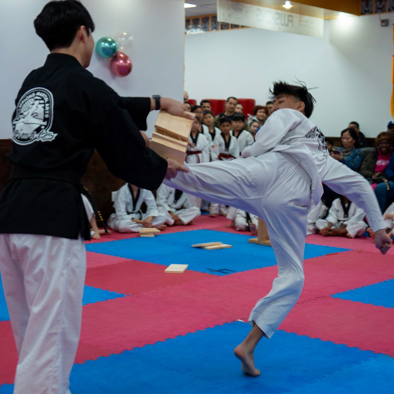 a group of people are practicing karate in a gym .