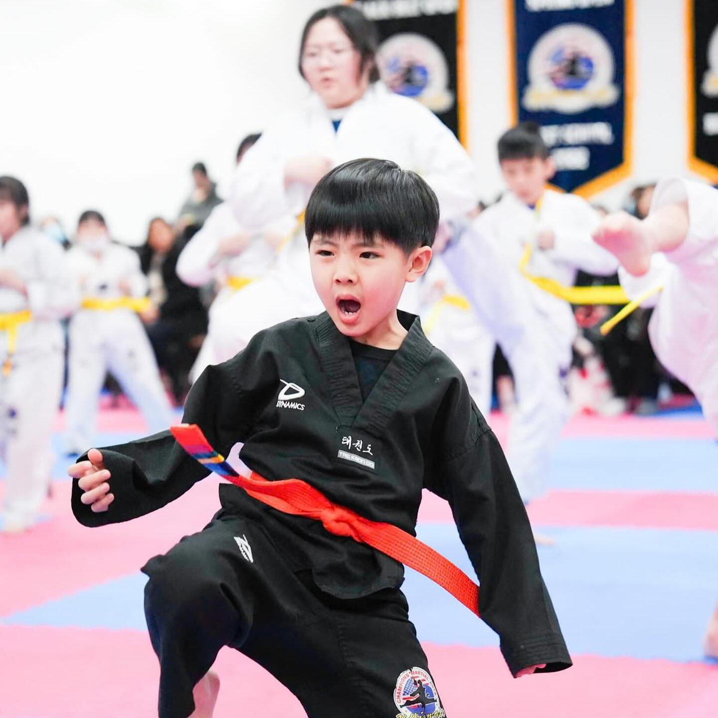 A young boy wearing a black karate uniform with the number 2 on it