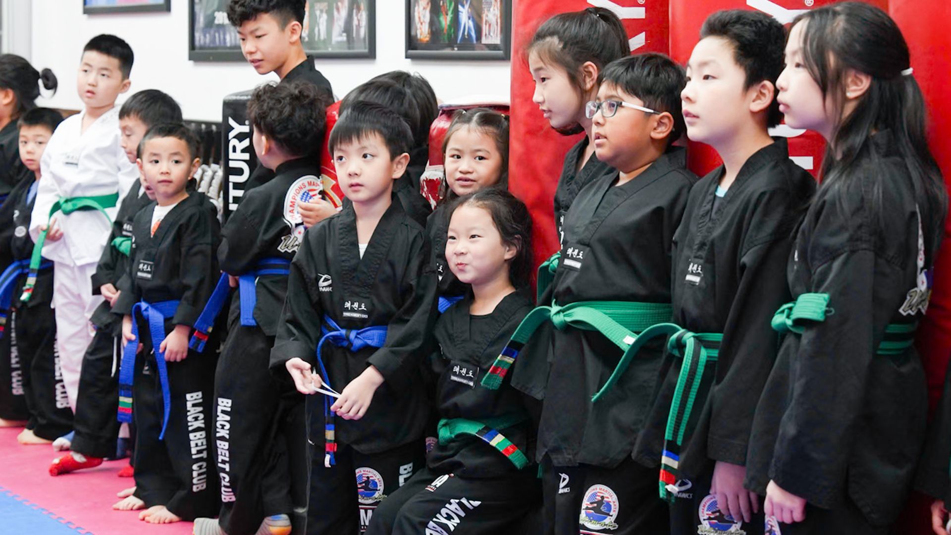 a boy and a girl are posing for a picture in a martial arts gym