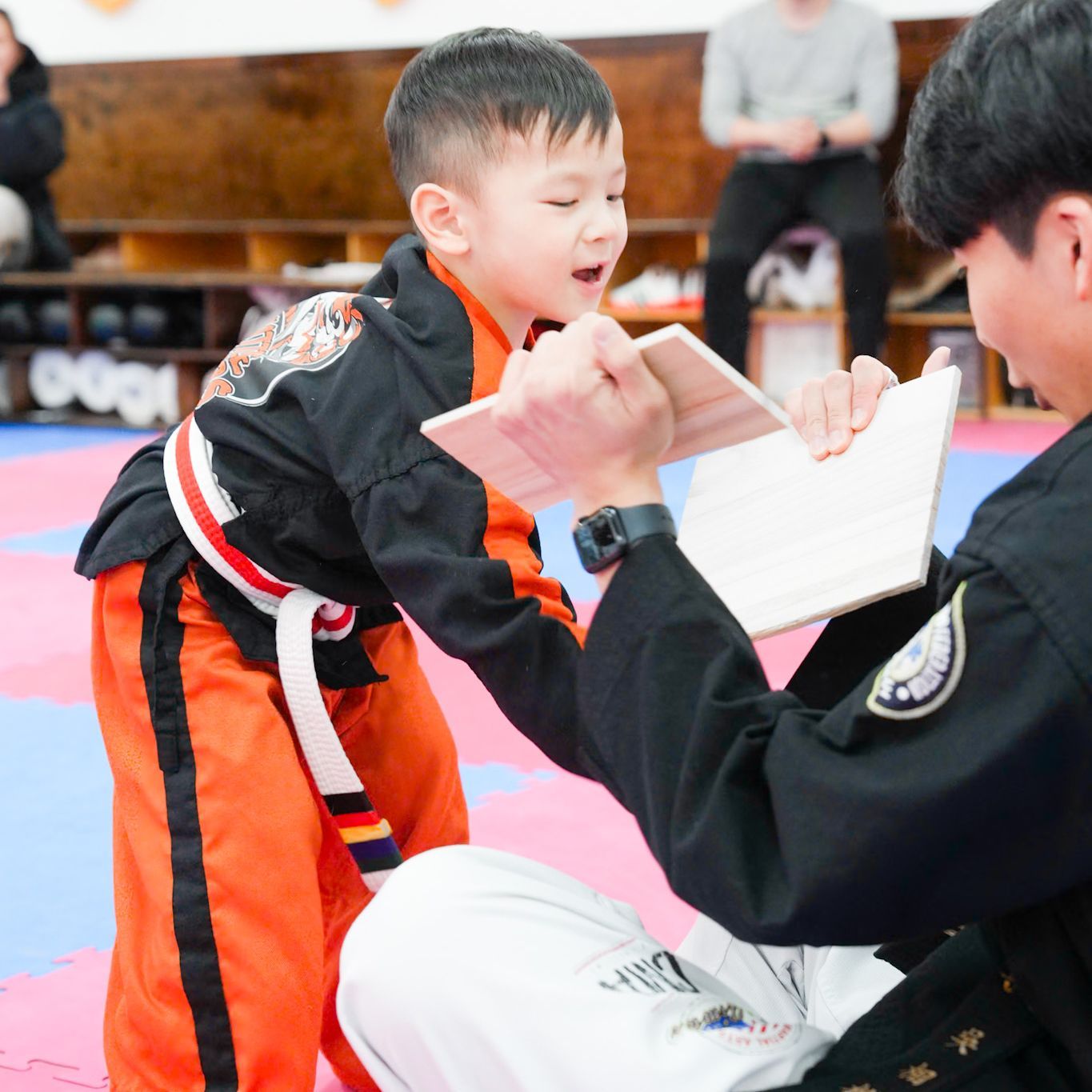 A man is teaching a young boy martial arts