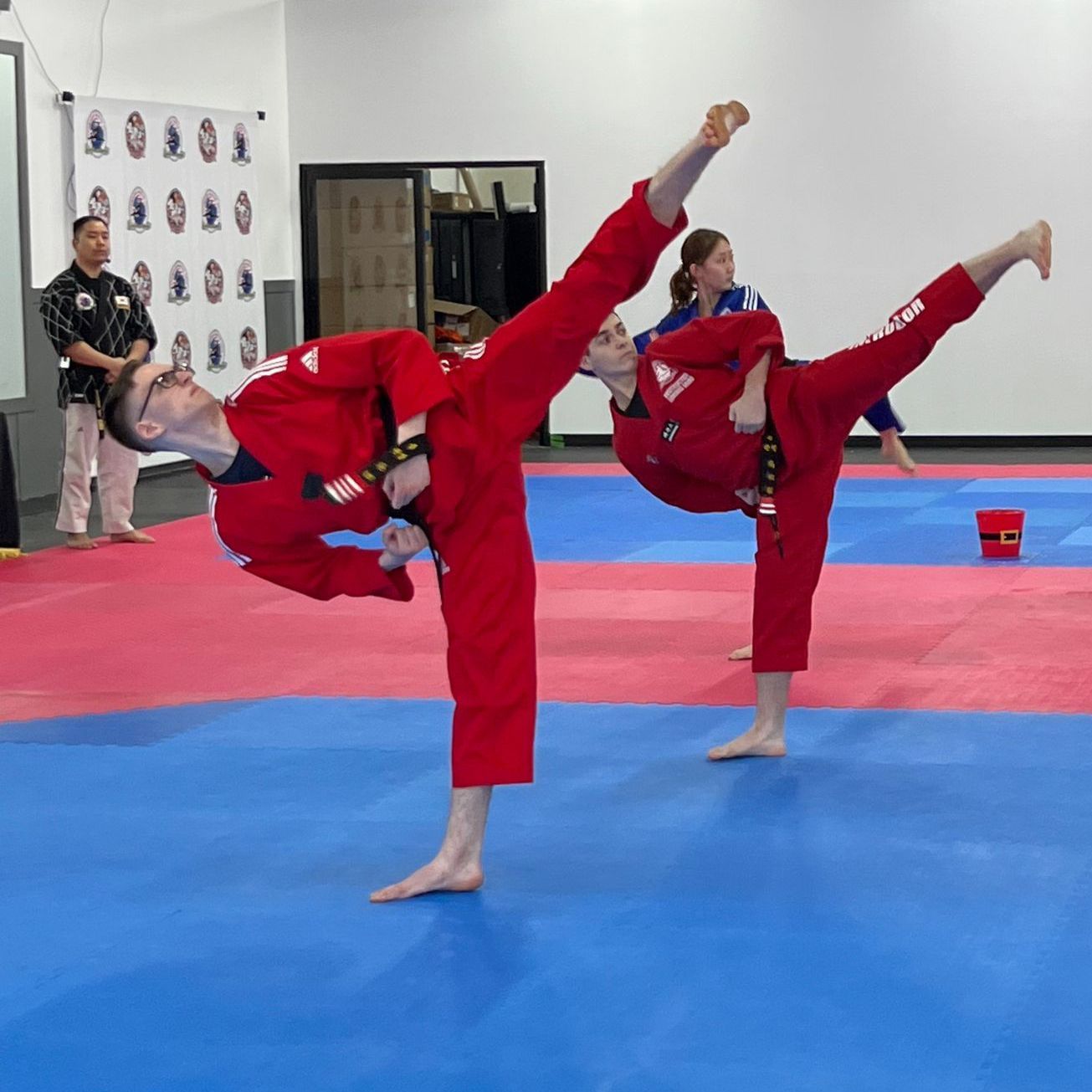 A group of people are practicing martial arts on a mat