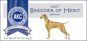 A dog is standing in front of a banner that says akc breeder of merit